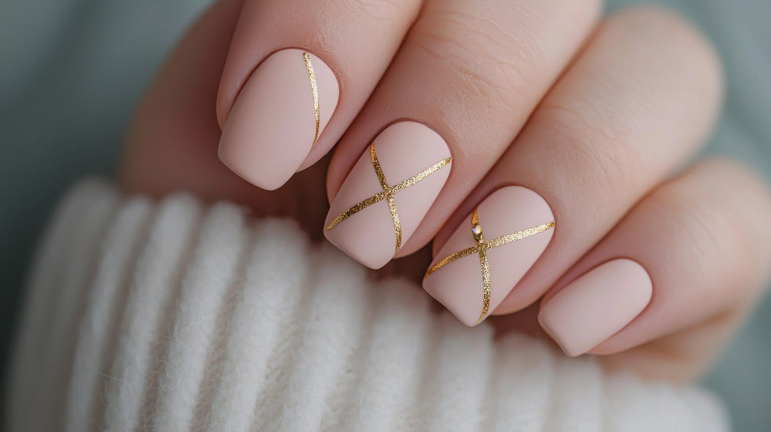 nude manicured nails with gold shapes