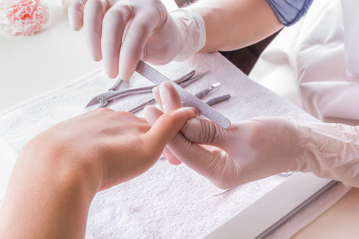 professionelle Nageldesignerin führt eine Maniküre durch