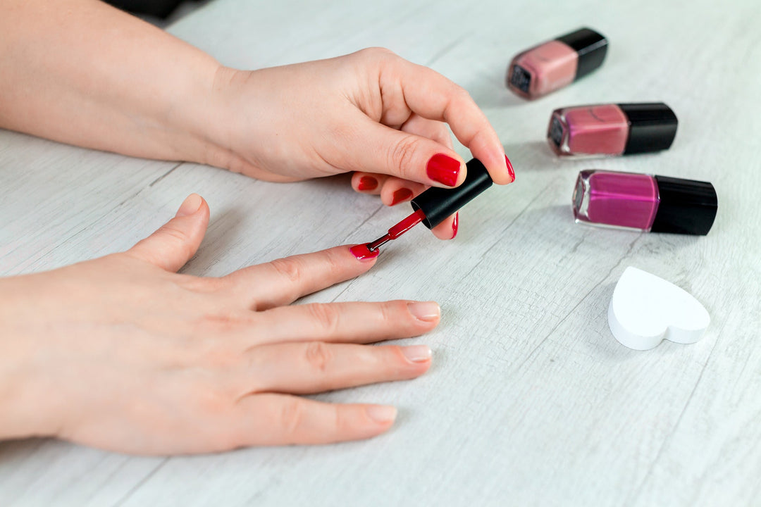 femme appliquant du vernis à ongles