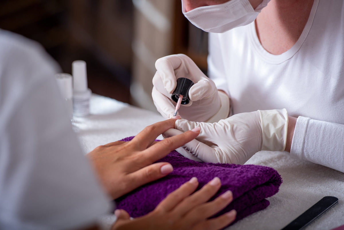 Nageldesignerin führt eine Maniküre durch