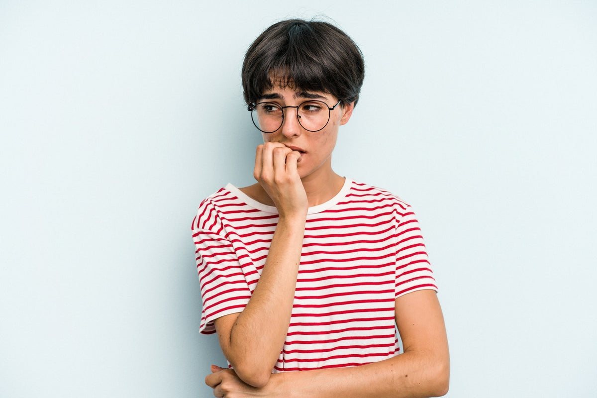 woman biting nails looking anxious