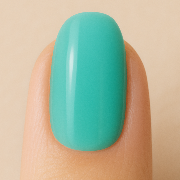 Turquoise gel polish on a finger against a beige background