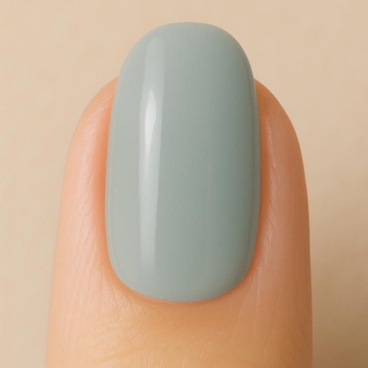 Light-grey gel nail polish painted on a nail 